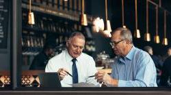一位男性导师在咖啡店与客户交谈